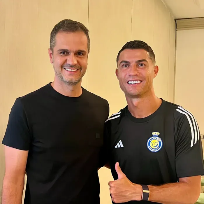 Thiago Taveira ao lado de um jogador profissional, os dois sorrindo